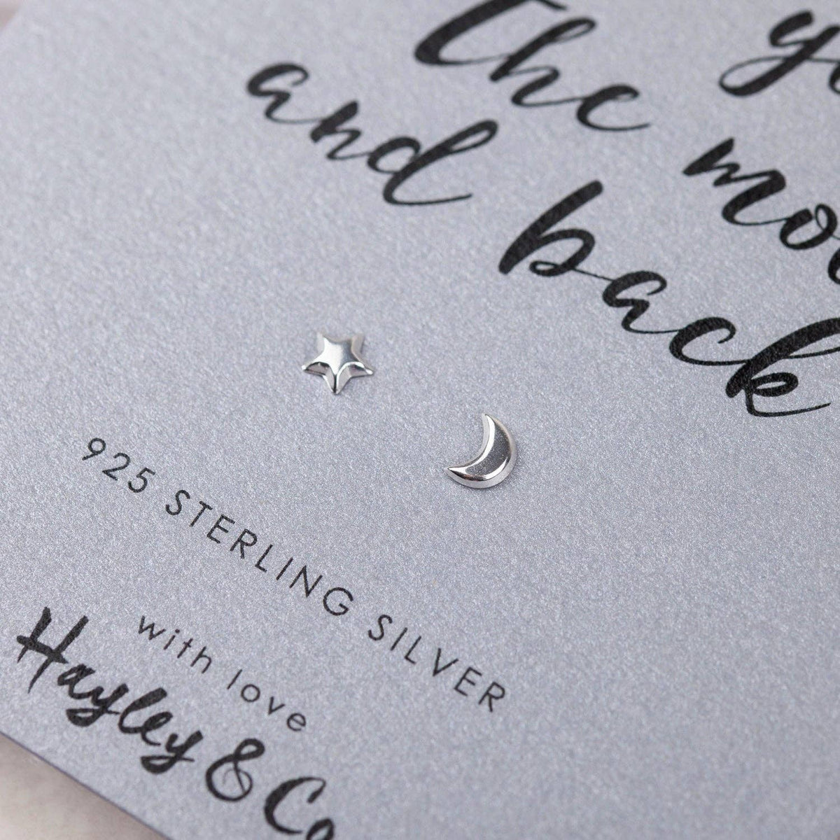 Sterling silver star and crescent moon stud earrings displayed on a light gray textured gift card with the text '925 STERLING SILVER' and 'Hayley & Co'.